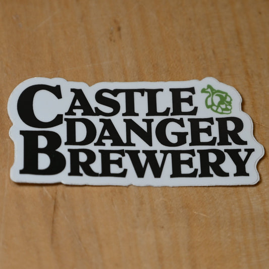 Sticker with 'Castle Danger Brewery' text on a wooden surface
